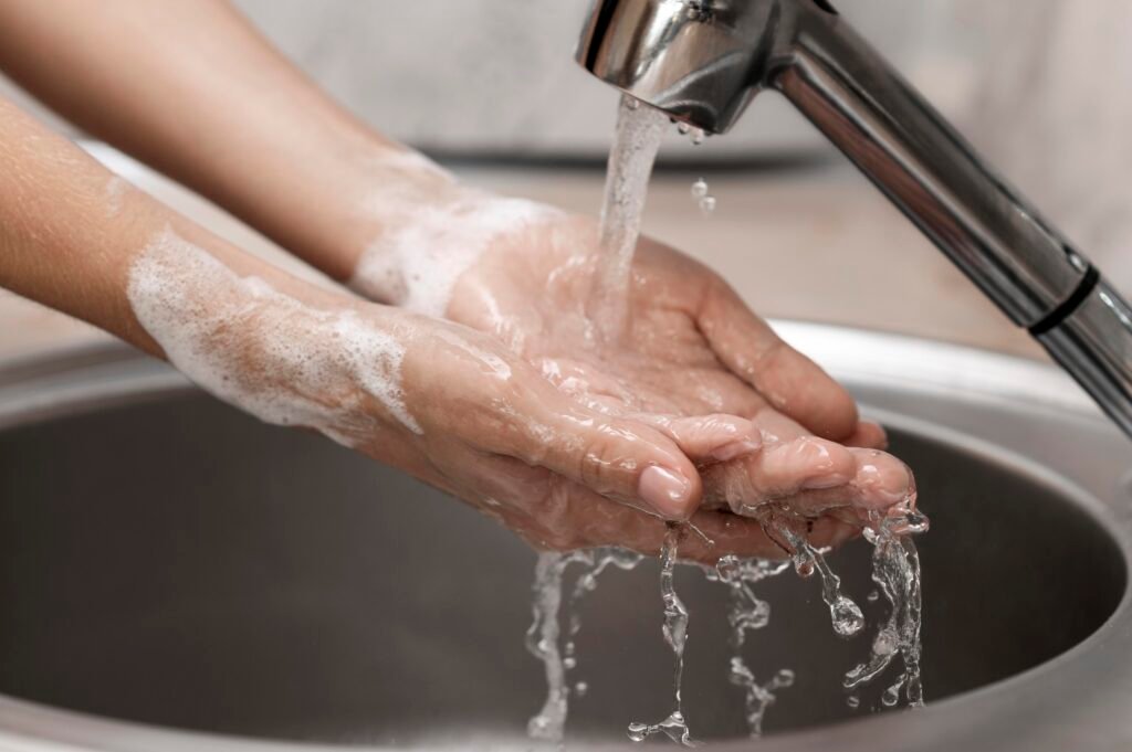 person washing hands sink close up