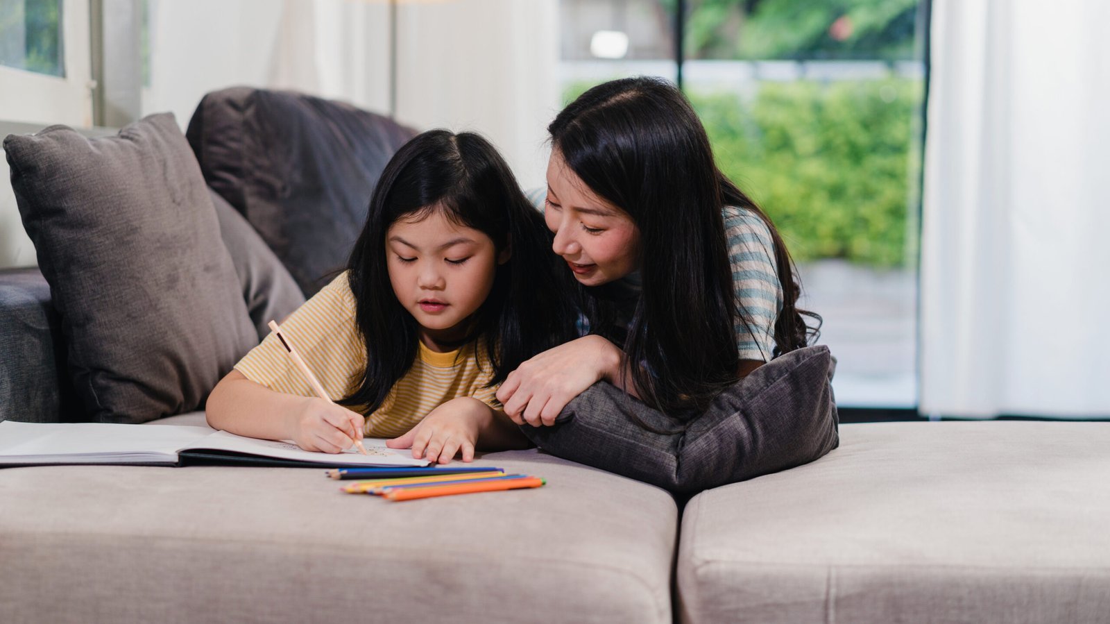 asian middle aged woman teach her daughter do homework and drawi